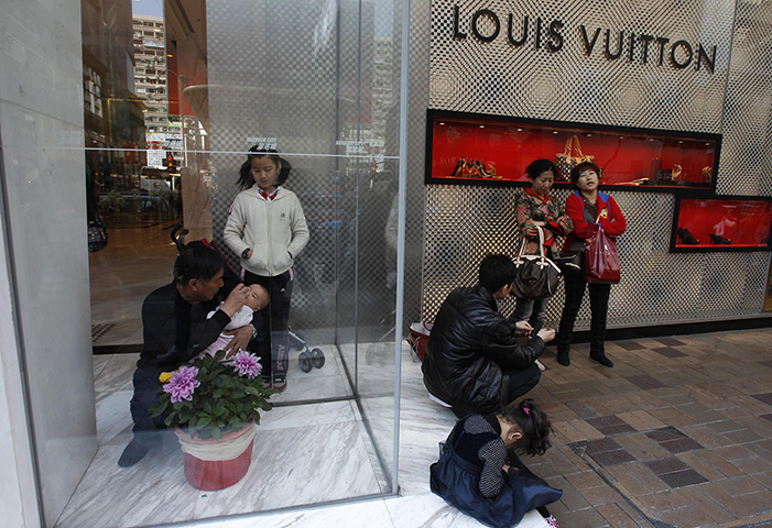 Week in Business: A mainland Chinese visitor feeds a baby at a Louis Vuitton store, Hong Kong