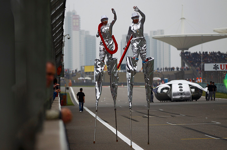 24 hours: Shanghai, China: Performers walk on stilts before the Chinese F1 Grand Prix