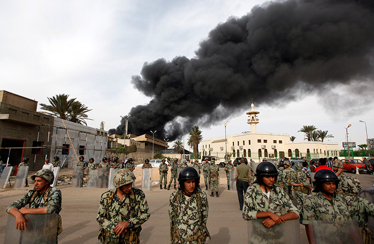 24 hours: Suez, Egypt: Army soldiers stand guard as smoke billows from a fire
