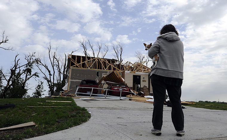 Tornado damage: A woman holds her dog in front of her damaged house in Wichita, Kansas