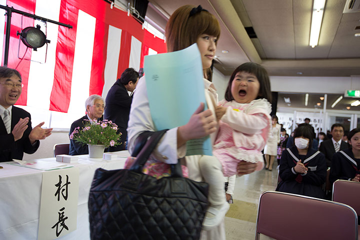 Kawauchi, Japan: Children and their parents, new to the school, are applauded as they enter