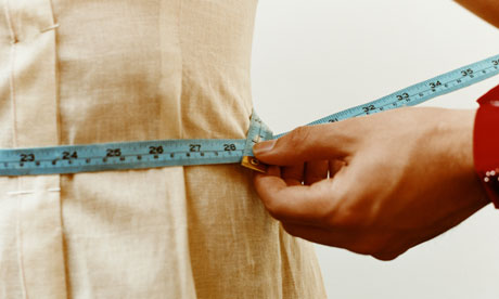 Measuring woman's waist with tape measure 