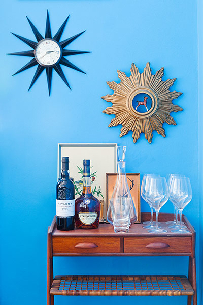 Homes Feature: Homes feature, drinks on a table in front of a blue wall with mirrors on