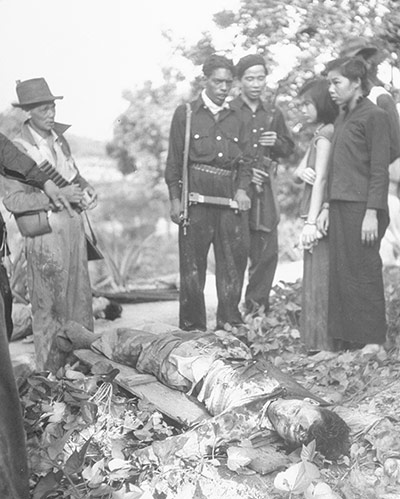 Colonial papers: Police standing over bodies of slain Communist in Malaya