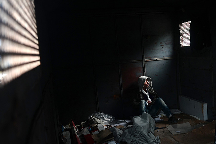 24 hours: Orestiada, Greece: Mohamed from Algeria, sits inside an abandoned wagon