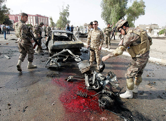 Picture Desk Live: security personnel inspect the site of a car bomb attack in Iraq