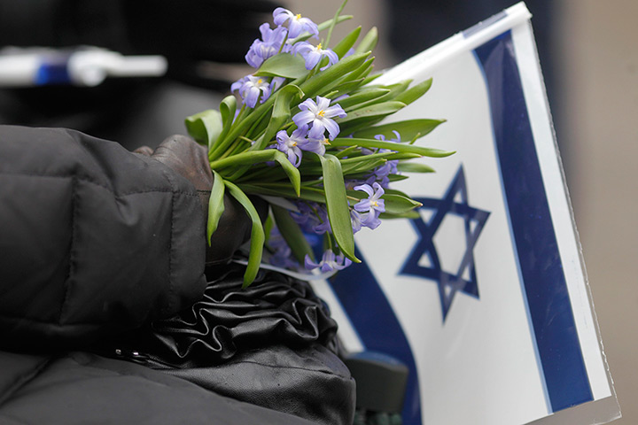 Holocaust memorial: A woman holds flowers and Israel's flag at the March of the Living