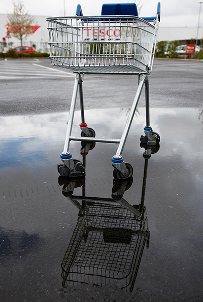 Week in Business: A shopping trolley sits in a puddle of water at a Tesco car park