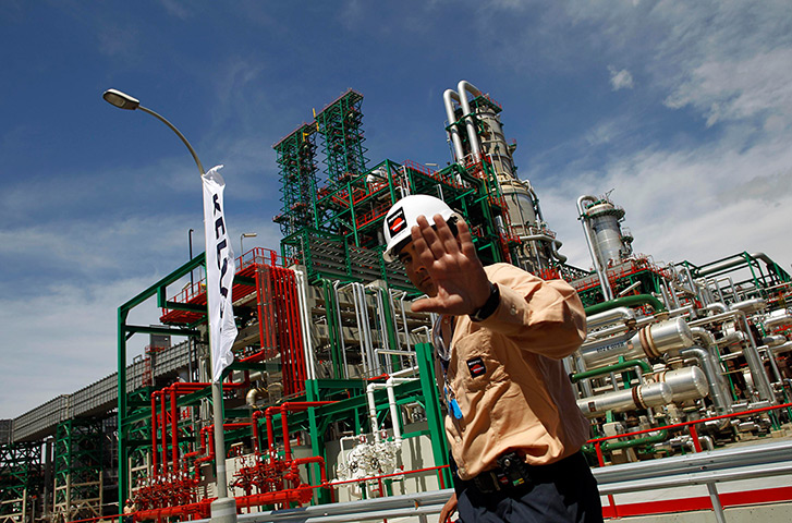 Week in Business: A Repsol worker walks past the Repsol oil refinery in Cartagena, Spain