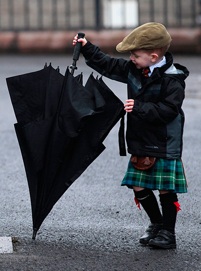 Picture Desk Live: A boy with an umbrella during a parade for soldiers in Forfar