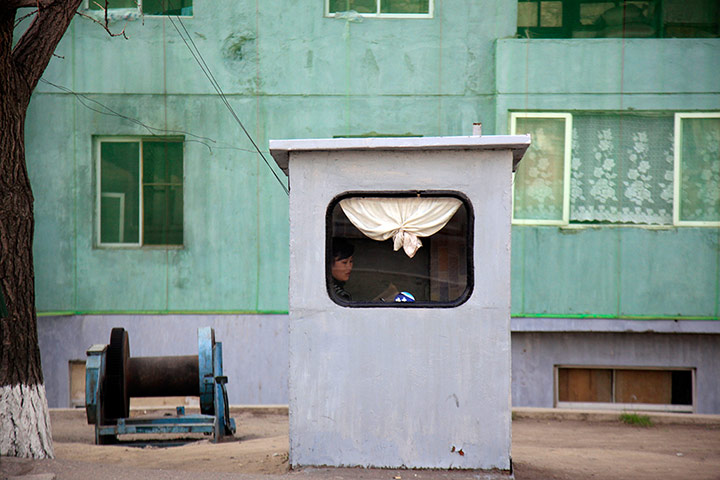 Longer view: A woman sits inside a booth on a street in Pyongyang, North Korea