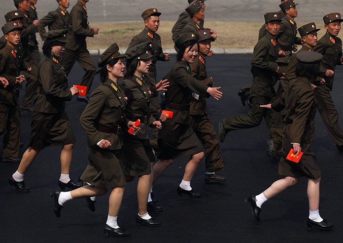 Longer view: Soldiers run into a stadium to join a ceremony in Pyongyang