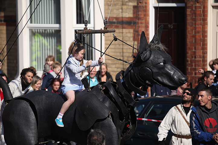 Liverpool Royal de Luxe: A girl rides the giant pet dog of the Little Girl Giant Marionette