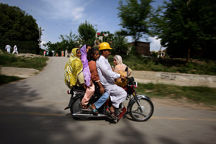 Picture Desk Live: A Pakistani couple and their three daughters, ride a motor bike