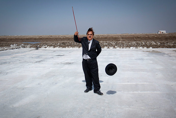 From the Agencies: Aswani poses on a salt pan in Adipur with his Charlie Chaplin hat and stick