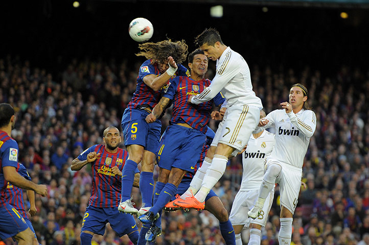El Clasico: Cristiano Ronaldo heads the ball while under pressure