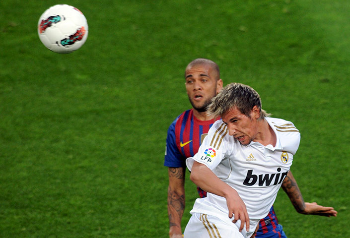 El Clasico update: Fabio Coentrao heads the ball away while Dani alves looks on 