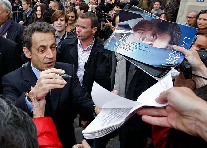 French elections: Nicolas Sarkozy signs autographs as he leaves a polling station