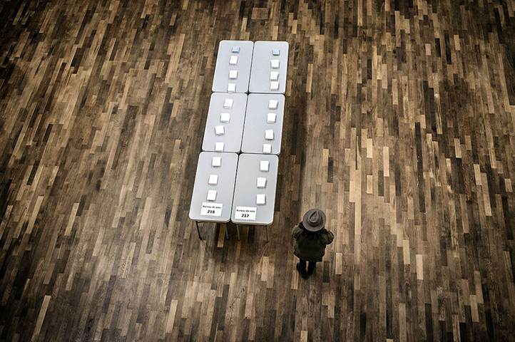24 hours in pictures: A person stands next to ballots on a table in a polling station in Lyon