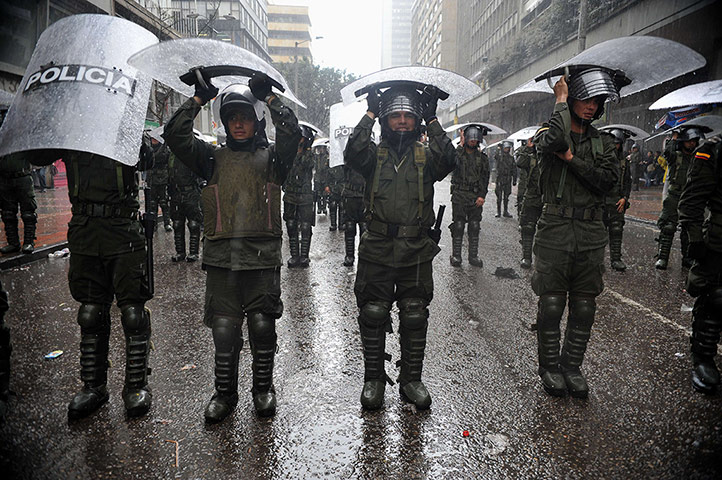 Picture desk live: Riot police shelter from the rain in Bogota, Colombia