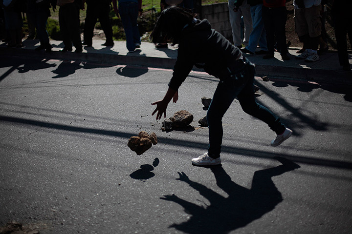 24 hours in pictures: A woman places stones on the road during a demonstration, Guatemala City