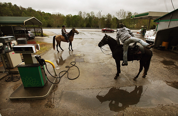 24 hours in pictures: Horse riders prepare to depart after a break at a gas station