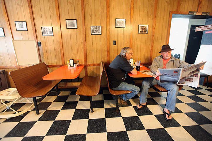 Booneville, Kentucky: A man reads a newspaper in a restaurant