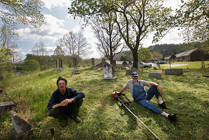 Booneville, Kentucky: Men sit while taking a break from cleaning a cemetery