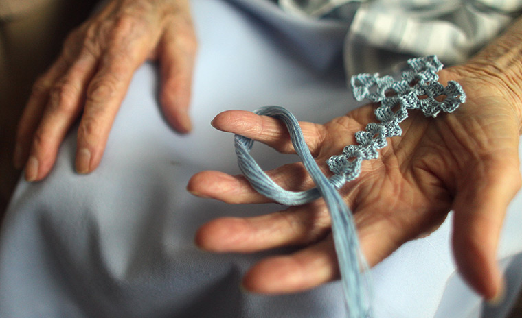 Booneville, Kentucky: Cora McIntosh displays a cross she knitted 