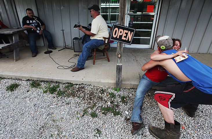 Booneville, Kentucky: Revelers hug at Joe's Meat Market #2 in Owsley County