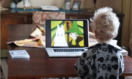 A two year old boy watching children's tv on laptop