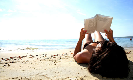 Woman reading a book on a beach