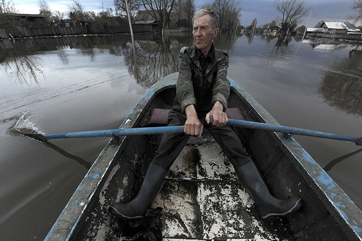 24 hours: Kadom, Russia: A man rows a boat in a flooded town in the Ryazan Region