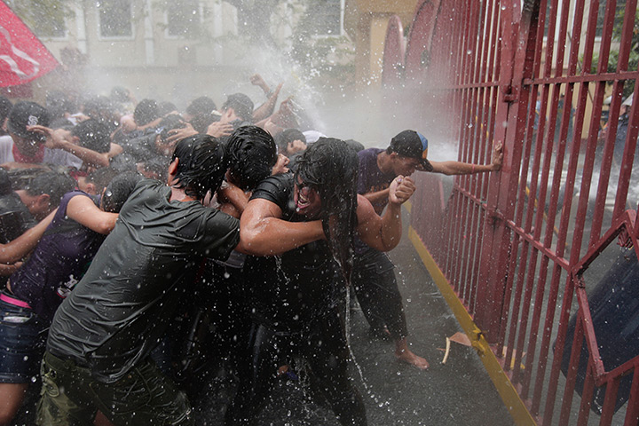 24 hours: Manila, Philippines: Protesters hold on as they are hit by water cannon