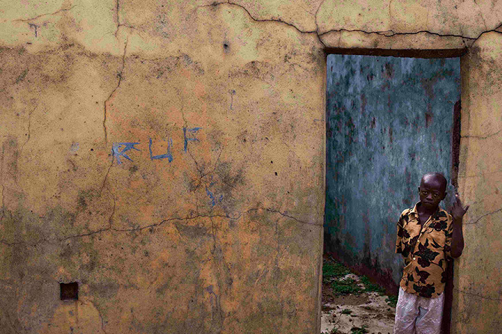 Sierra Leone after Taylor: Boy stands in abandoned home damaged during 1991-2002 civil war