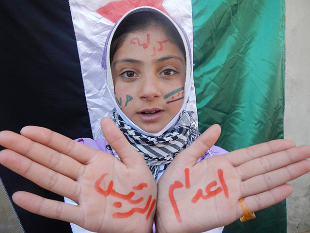 Picture Desk Live Update: A girl takes part in a protest against Syria's President Assad in Kafranbel