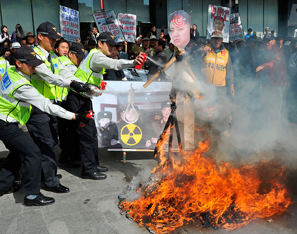 Picture Desk Live: Police use fire extinguishers after anti-North Koreans set fire to a paper 