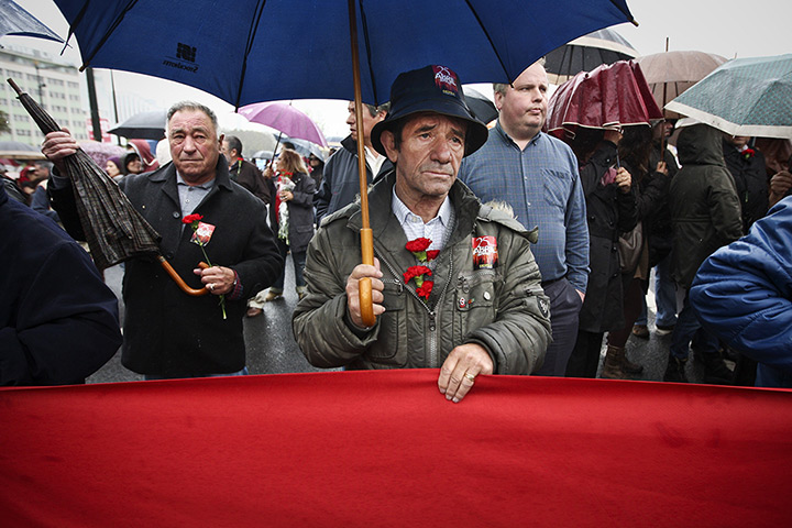 24 hours: Lisbon, Portugal: A man with red carnations tucked in his jacket
