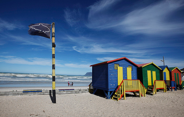 24 hours: Cape Town, South Africa: Beachgoers walk past shark warning flags