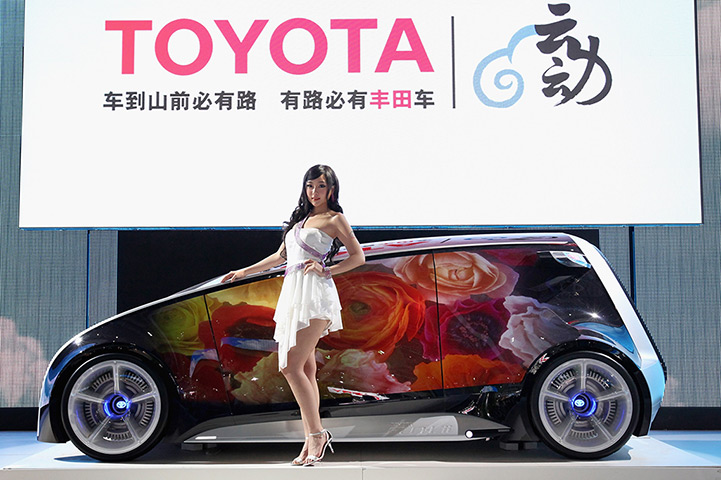 Week in Business: A model stands beside a Toyota Fun-Vii concept car Beijing Auto China 2012