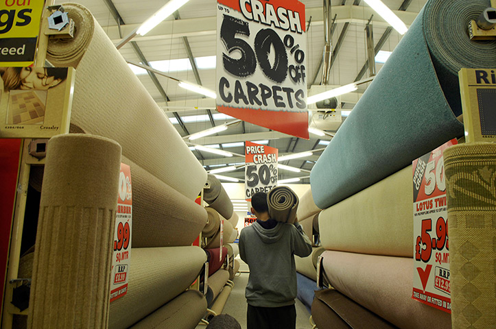 Week in Business: A customer carrying his purchase through a Carpetright store