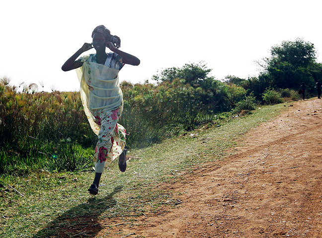 South Sudan: A woman runs along a road during an air strike by the Sudanese air force