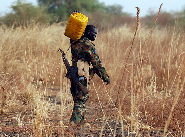 South Sudan: Soldier carries water to his position on the frontline in Panakuach