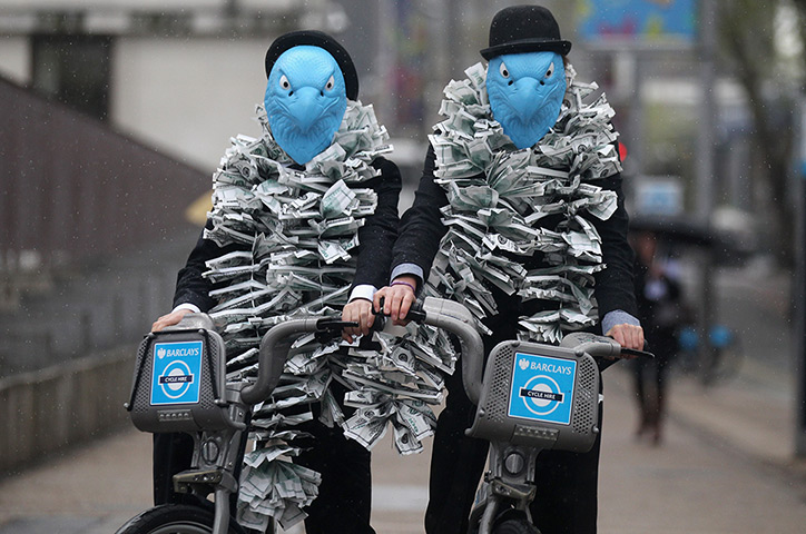 Picture desk live: Protesters dressed as suited eagles on Barclays cycle hire bikes