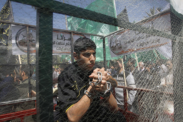 24 Hours: A Palestinian youth sits in side a mock cage in Gaza City