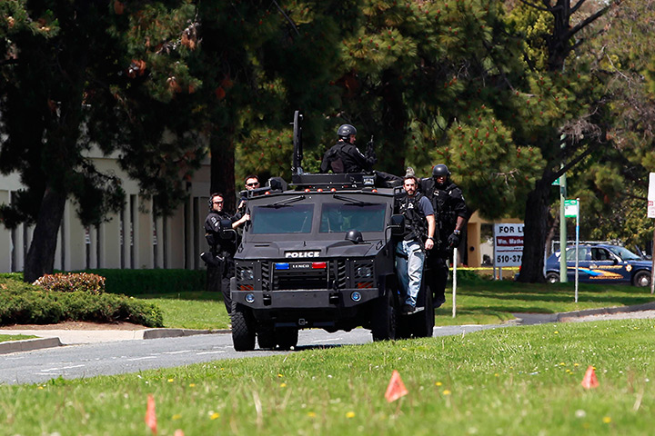 Oakland shooting: Police officers on an armoured vehicle survey the scene of a shooting