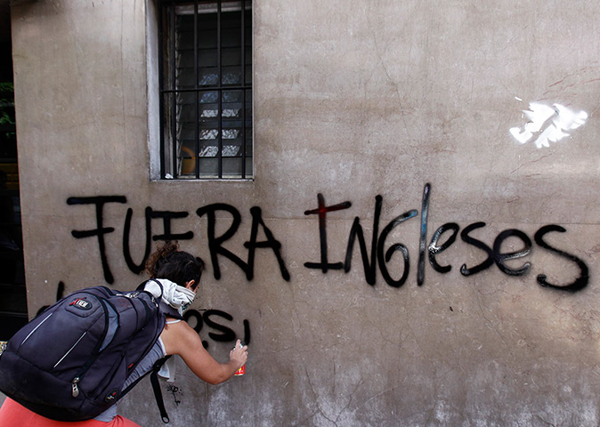 Falklands protests: A demonstrator spray paints a graffiti during a demonstration, Buenos Aires