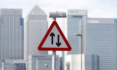A traffic sign in front of the skyline of the Canary Wharf