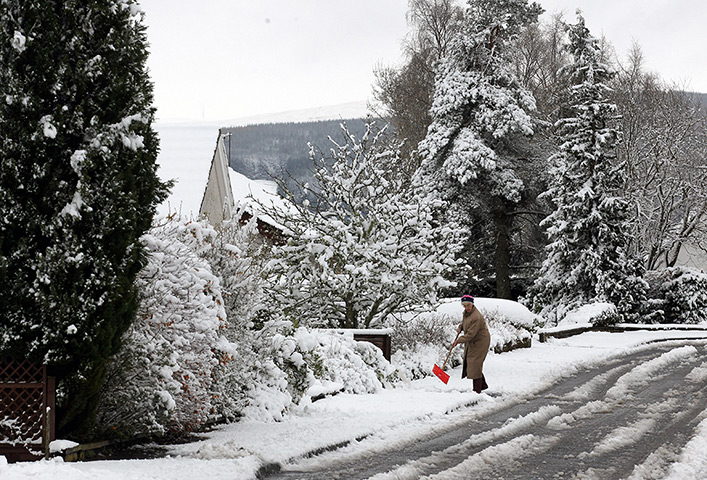 Snow returns: A woman clears the path of snow in her street at Auchterarder 