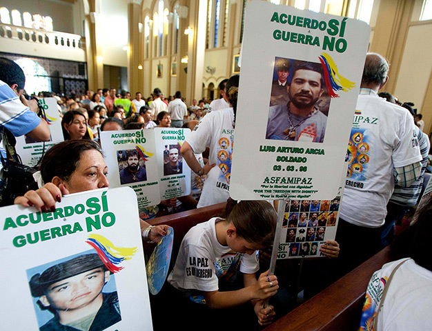 Colombia hostage release: Relatives of hostages hold up signs at a mass